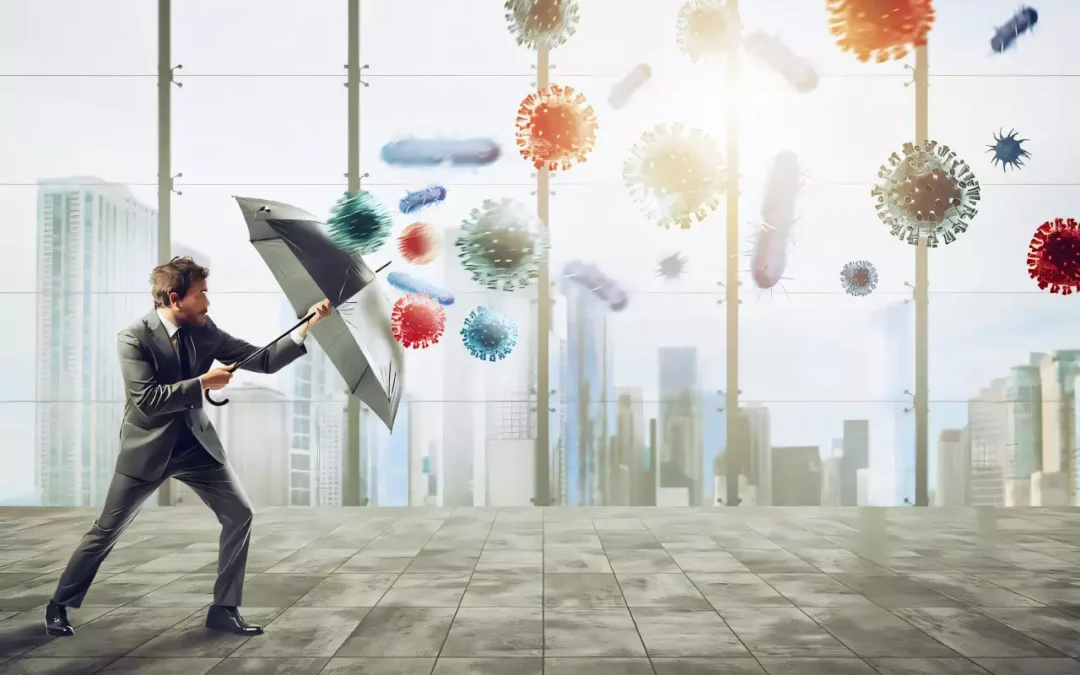 Homme d'affaires avec parapluie face à des virus, concept de protection financière.